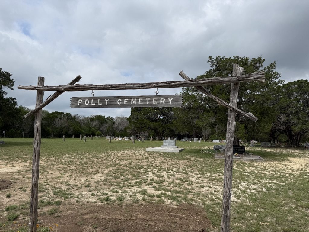 The timber-framed entrance arch reading Polly Cemetery