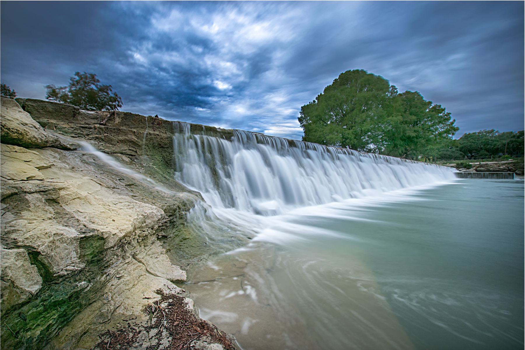 A Hill Country river running over a dam