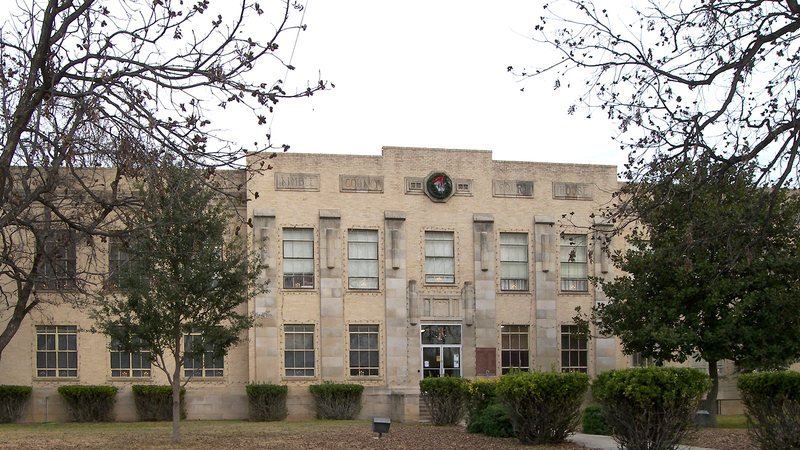 The limestone Kimble County Courthouse in Junction, framed by trees