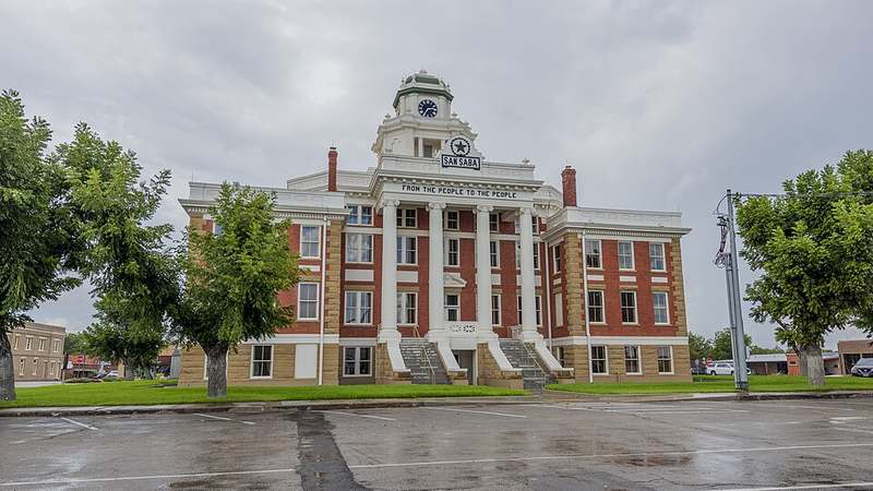 The red-brick San Saba County Courthouse with its clock tower and the motto From the People to the People