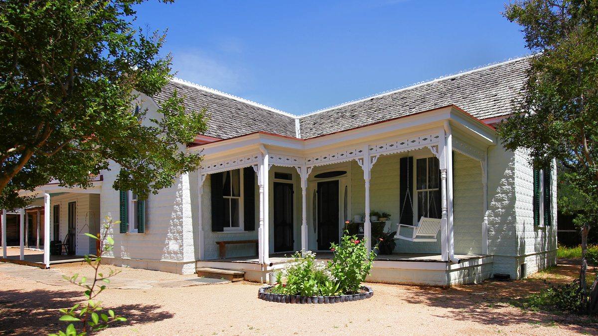 The white Victorian farmhouse and porch swing at Sauer-Beckmann Farm, Stonewall